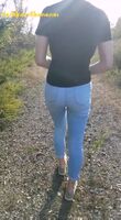 Wetting her jeans while walking on the side of the road